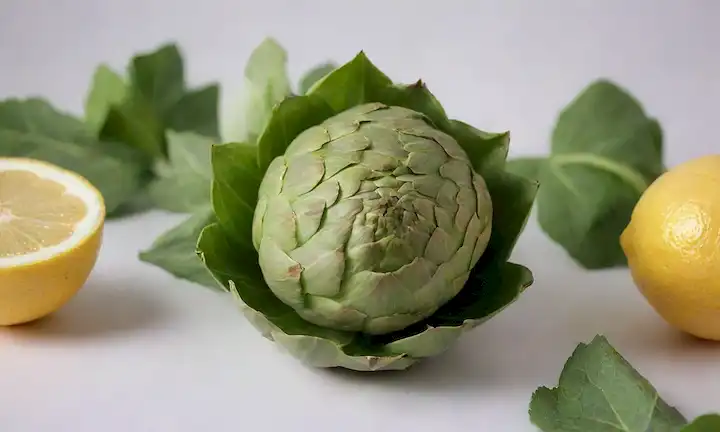 Una alcachofa verde brillante en un fondo blanco con un gradiente sutil