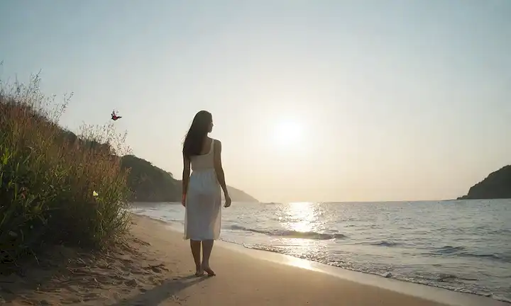 Un sol brillante, una flor floreciente, una mariposa emergente, ondas suavemente lampadas en una costa serena, un paisaje pacífico, una figura segura de pie alto, manos abiertas al cielo, con sombras sutiles y luz suave, transportando la calma y la serenidad, rodeada de vegetación