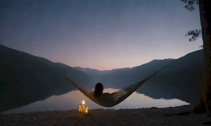 Calma cielo nocturno con estrellas, olas tranquilas que chocan en la orilla, velas encendidas, bosque tranquilo o paisaje montañoso, persona que relaja en una hamaca, suave niebla que se levanta del agua, ambiente natural sereno, ambiente calmante