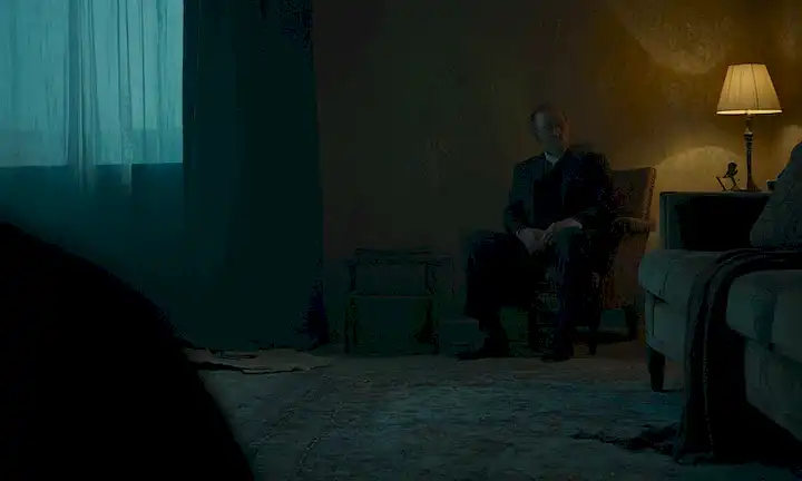 Un cuarto oscurecido con una figura en las sombras, un toque sutil de objetos rotos o tela rota, una imagen débil de una persona cara en el fondo, un sentido de la tensión y el precipicio, un uso dominante de los colores frescos, un efecto gradiente sutil para transmitir el desajuste