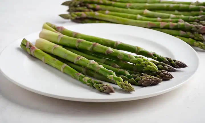Un plato con espárragos en un fondo blanco, hojas frescas y vibrantes, color verde brillante, posiblemente una sugerencia de
<center><img decoding=