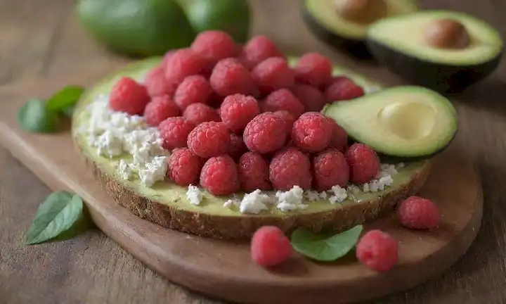 fresas frescas, aguacate maduro, queso defeta desmoronado, hojas verdes delicadas, bandeja de madera de tono terrenal, foco suave, luz natural cálida, encanto rústico