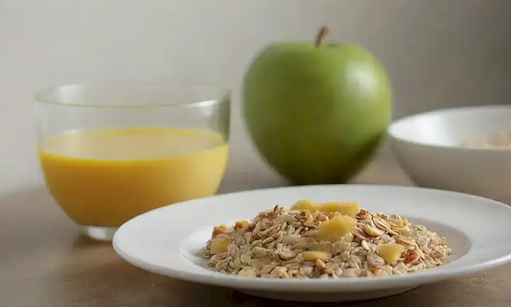 Una rodaja de kiwifruit en una placa blanca con un vaso de agua y un tazón de muesli en el fondo, mostrando beneficios digestivos, contenido de fibra y desayuno matutino, con iluminación natural cálida, composición minimalista y limpia
