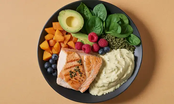 un plato con varias fuentes de proteínas como la pechuga de pollo, filete de salmón, lentejas, tofu, almendras y polvo de suero, rodeado de frutas y verduras como bayas, espinacas, aguacate, dispuesta en una composición armoniosa para transmitir nutrición