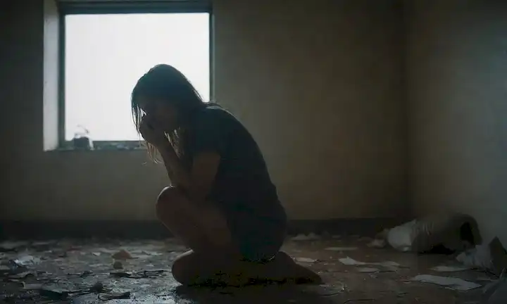 Una persona sentada sola en una sala encendida