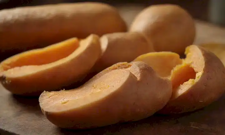 patatas dulces, marrón dorado, rebanadas abiertas, subidas de vapor, mesa de madera rústica, iluminación cálida, colores otoñales, aromas de encaje, hierbas frescas, corteza de pastelería delicada, bordes ahumados, textura tentadora, pantalla de enjuague bucal