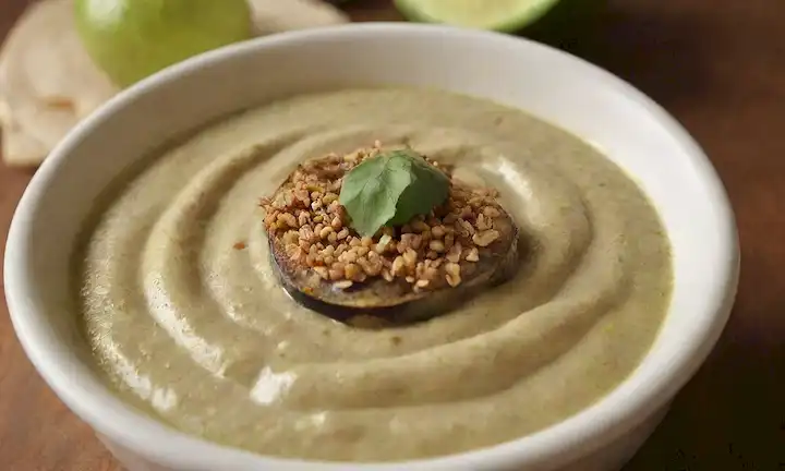 berenjena tostada, tahini cremoso, zumo de limón verde brillante, semillas de sésamo crujiente, hummus suave, bordes dorados marrones, colores vibrantes, presentación de bufanda, aroma atractivo, textura apetitosa