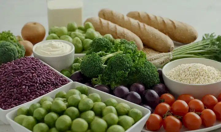 Un paisaje sereno con un enfoque en alimentos saludables, verduras verdes y granos enteros, con una muestra prominente de colores púrpuras ricos y vibrantes, con sutiles toques de blanco y crema, transmitiendo un sentido de nutrición y bienestar